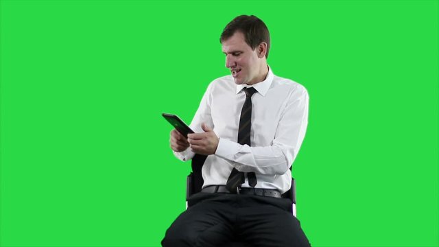 Businessman with digital tablet. Young modern white-collar worker. Online video chat on tablet on green screen.