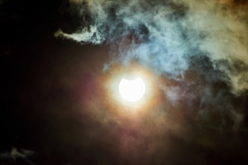 Obraz na płótnie Canvas Solar Eclipse on a cloudy day. Partial solar eclipse viewed under cloudy skies. 