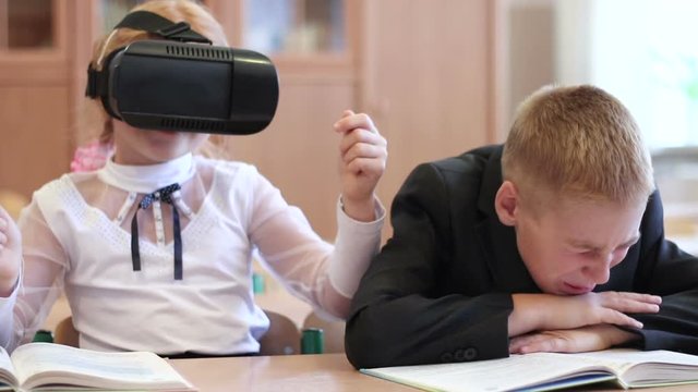 Schoolgirl use of VR goggles in lessons. Virtual reality technology for children in a modern school.