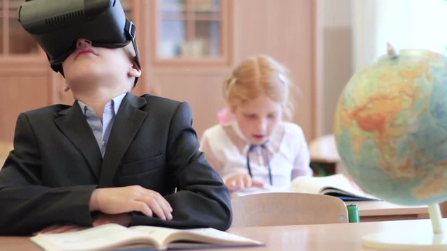 Students in classroom. Virtual reality technology for children in a modern school. Schoolgirl use of VR goggles in lessons. Pupils online elementary school.