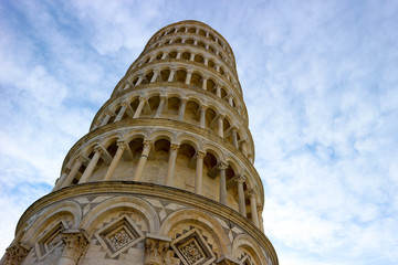 Closeup view to leaning tower of Pisa, symbol of Italy, with the clouds and blue sky on the background