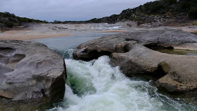 Slow motion of milky white water river flowing with power at Pedernales State Park In Texas