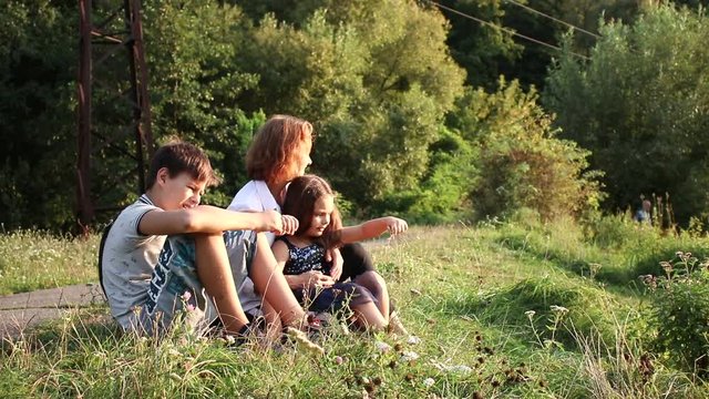 Happy family in the park. Mother with her children and dog walking in summer forest. Family outdoor leisure in park.