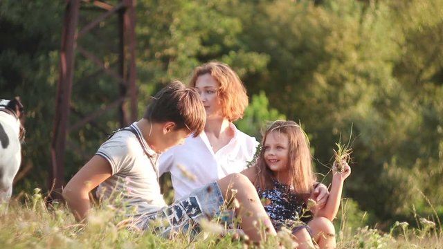 Mother with her children and dog walking in summer forest. Family outdoor leisure in park.