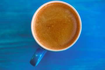 Coffee mug on a wooden turquoise background.