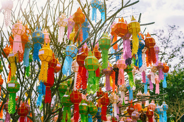 The multi-color of Lanna prayer lanterns decoration on a tree in ceremonies at a Buddhist temple of northern Thailand.