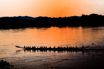 Rowing athletes are training paddlers at the river in the evening while sunset