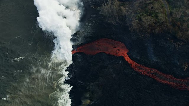 Aerial view molten lava pouring into Pacific ocean