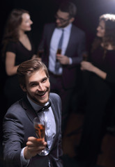 stylish young man raising a glass of wine
