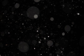 Background of falling snowflakes in the light of a lantern.