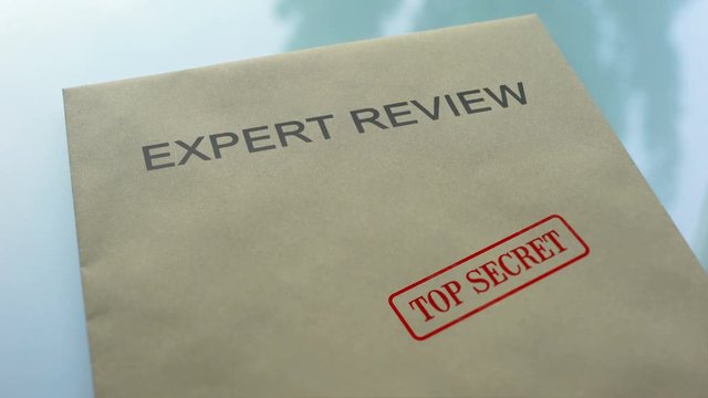 Expert review top secret, hand stamping seal on folder with important documents