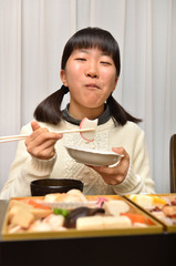 おせち料理を食べる女の子(正月)