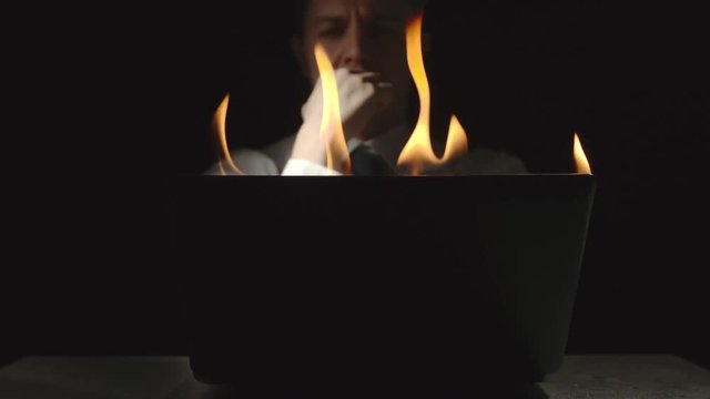 Businessman is thinking at the burning laptop - Slow Motion