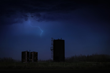 Fototapeta na wymiar Bitumen tanks under a dark stormy sky