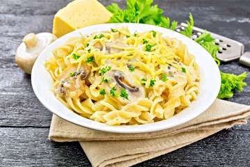 Fusilli with mushrooms and cream on black board