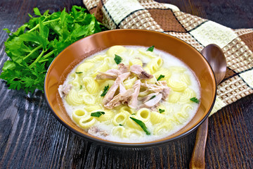 Soup creamy of chicken and pasta in plate on dark table