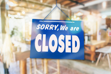 Sorry we are closed sign hang on door of business shop.