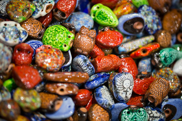 Ceramic souvenirs and decorations. Neck pendants for aroma oils. Bright background.