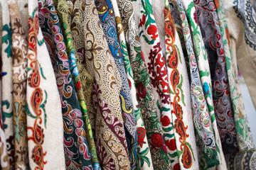 A closeup view of a colorful fabric with a traditional oriental ornament. Hand-made, traditional cloth and embroidery. Bright beautiful colors. Traditional oriental background.