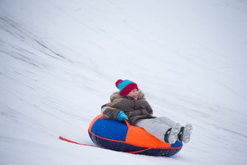Fototapeta na wymiar Sledding.Happy child on vacation. Winter fun and games.Little boy enjoying a sleigh ride.Children play outdoors in snow. Kids sled in the Alps mountains in winter