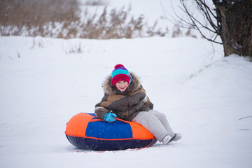 Fototapeta na wymiar Sledding.Happy child on vacation. Winter fun and games.Little boy enjoying a sleigh ride.Children play outdoors in snow. Kids sled in the Alps mountains in winter