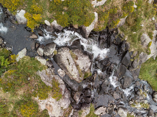 Obraz premium Aerial drone view landscape of river flowing down waterfall and over rocks in Snowdonia