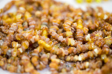 Raw amber stones, simple beads. Close-up. Amber background.