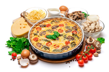 Baked homemade quiche pie in ceramic baking form, eggs and cream