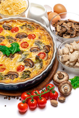 Baked homemade quiche pie in ceramic baking form, eggs and cream