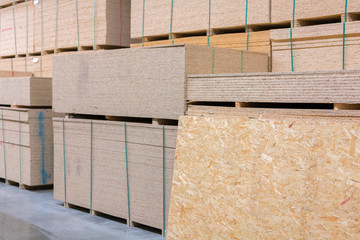 lumber osb, plywood, mdf, project panel at hardware store in USA. Wooden bars, flake board, sterlingboard on shelves inside lumber yard of home improvement retailer. Customer shopping.