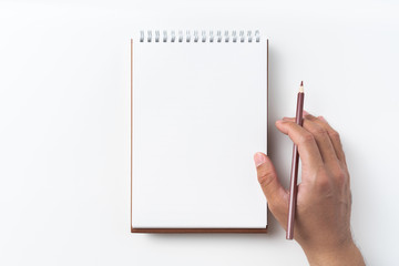 Top view of brown spiral notebook with hand