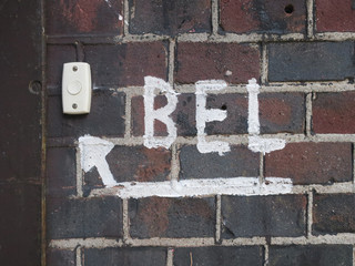 doorbell with a sign of an arrow attending to the bell on a wall in Amsterdam