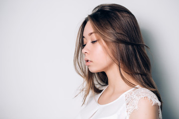 Obraz premium Sideways portrait of sad unhappy woman on a white background with copy space