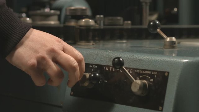 Hand using old film editing equipment