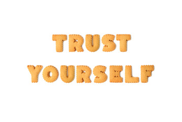 Top view of the word TRUST YOURSELF spelled with alphabet shaped biscuits isolated on white background