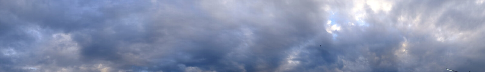 Panorama evening sky with blue, white and gray clouds.