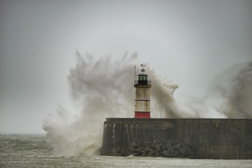 Fototapeta na wymiar Stunning dangerous high waves crashing over harbor wall during windy Winter storm at Newhaven on English coast