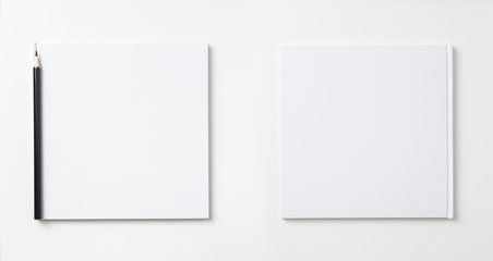 Top view of white notebook, page, pencil