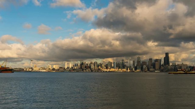 UHD 4k time lapse video of fast moving clouds and blue sky over downtown city skyline along Elliot Bay from Alki Beach in Seattle Washington 3840x2160