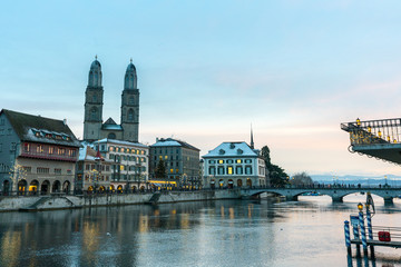 Fototapeta na wymiar Zurich, ZH / Switzerland - January 4, 2019: many people crossing a bridge over the Limmat on their way to the Grossmuenster cathedral in Zurich