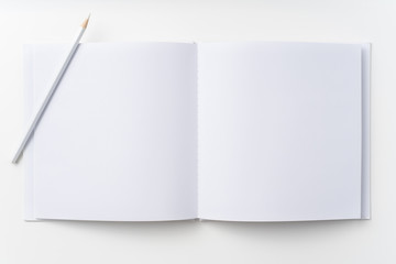 Top view of white notebook, page, pencil