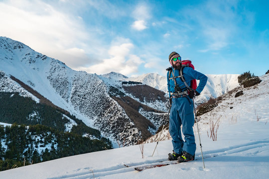 A man is engaged in ski touring on splitboarding. Sunrise in the mountains