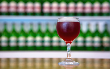 Cold wine in a glass on the background of bottles.