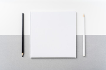 Top view of white hardcover notebook, pencil