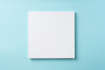 Top view of white hardcover notebook on blue