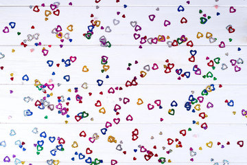 Old fashion pale multi colored heart on white wooden background with copy space, flat lay