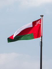 Omani flag waving in the blue sky