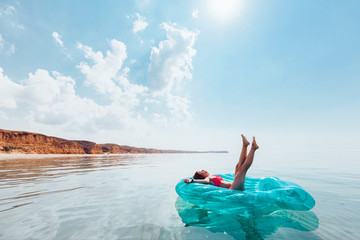 Girl relaxing on inflatable ring on the beach