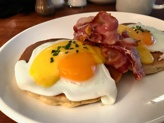 Salted Pancakes with Hollandaise Suace, Eggs and Crispy Bacon for Breakfast. Salty Fast Food.