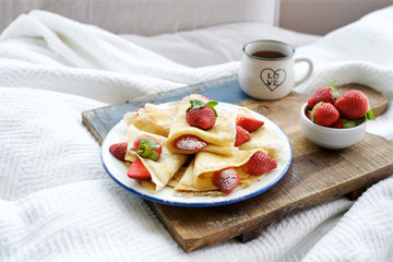 Traditional french Crepes Suzette with strawberry. Breakfast in bed
